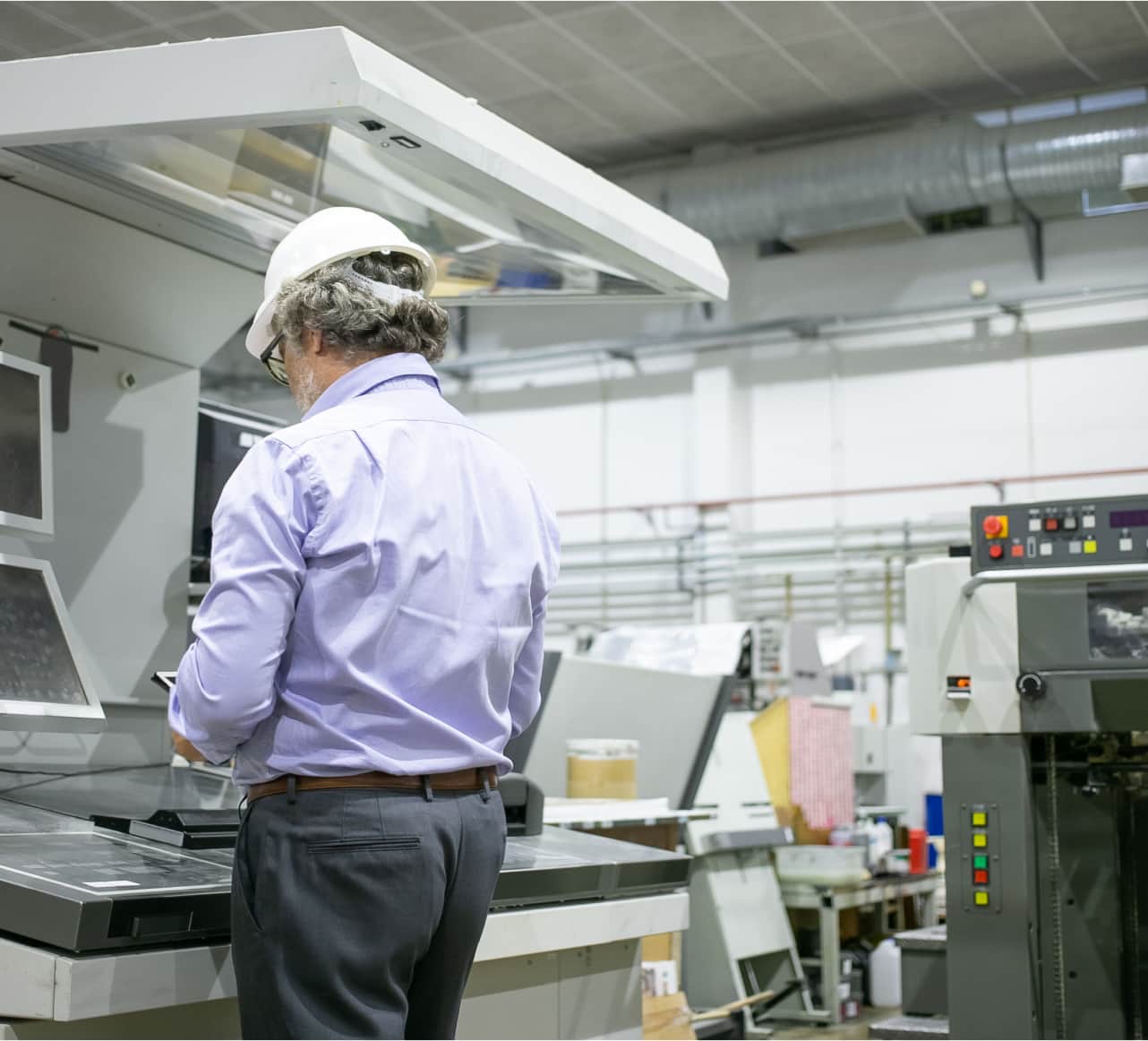 A man with a hard hat operating machinery